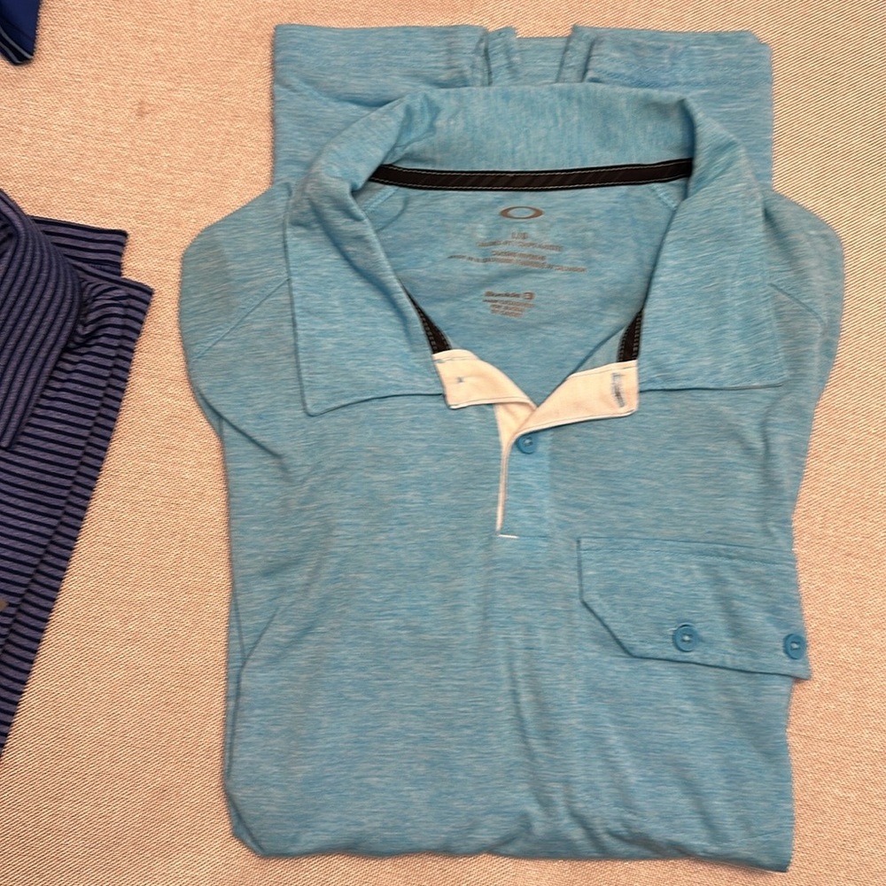 Bundle deal. 2 Large polo shirts. 1 is under armor and the other is Oakley.